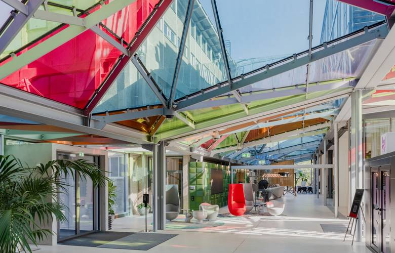 Eingangsbereich der Eventlocation PRISMA by Lumia mit buntem Glasdach nd Design-Elementen