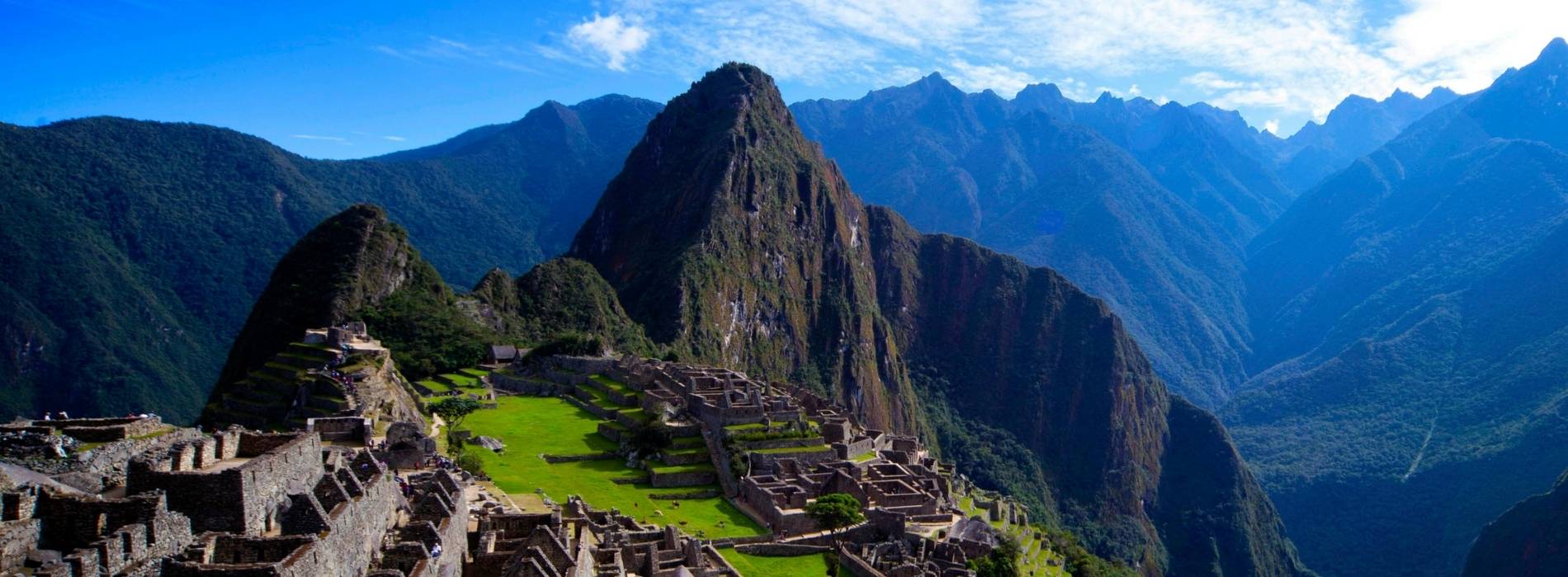 Machu Picchu in den peruanischen Anden mit terrassenförmigen Ruinen und umliegenden Berggipfeln.
