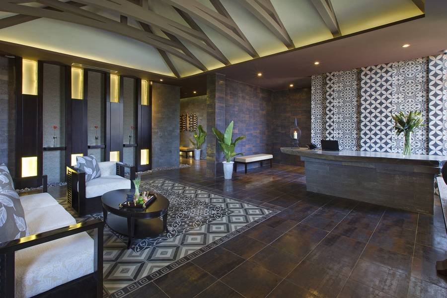 Stilvolle Hotel-Lobby mit dunklem, modernem Design, aufwendigen Fliesenmustern, eleganter Beleuchtung und gemütlichen Sitzgelegenheiten, ergänzt durch dekorative Pflanzen und eine einladende Atmosphäre.
