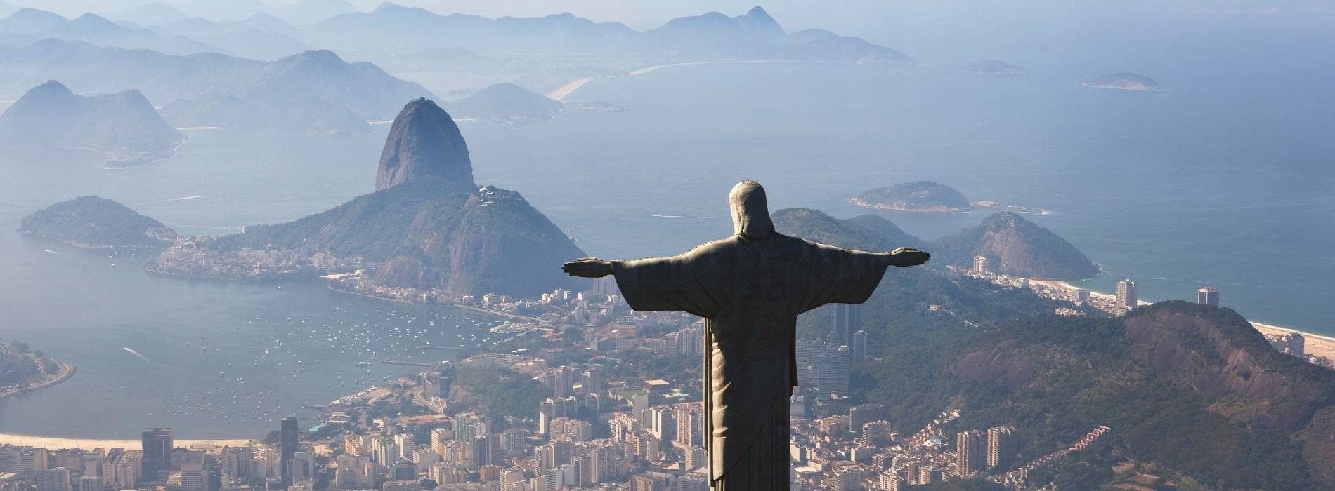 Christusstatue auf dem Corcovado mit Blick auf Rio de Janeiro und den Zuckerhut bei Sonnenaufgang