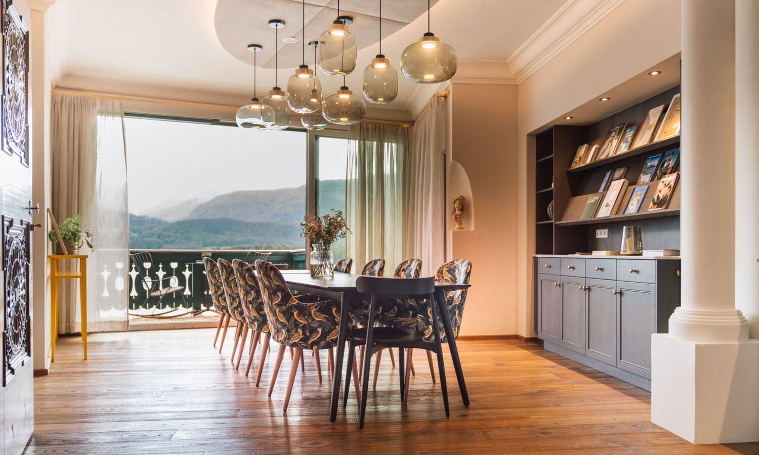 Modernes Atelier für Seminare mit Holzgeländer, Glaskugel-Leuchten und Panoramablick auf See und Berge