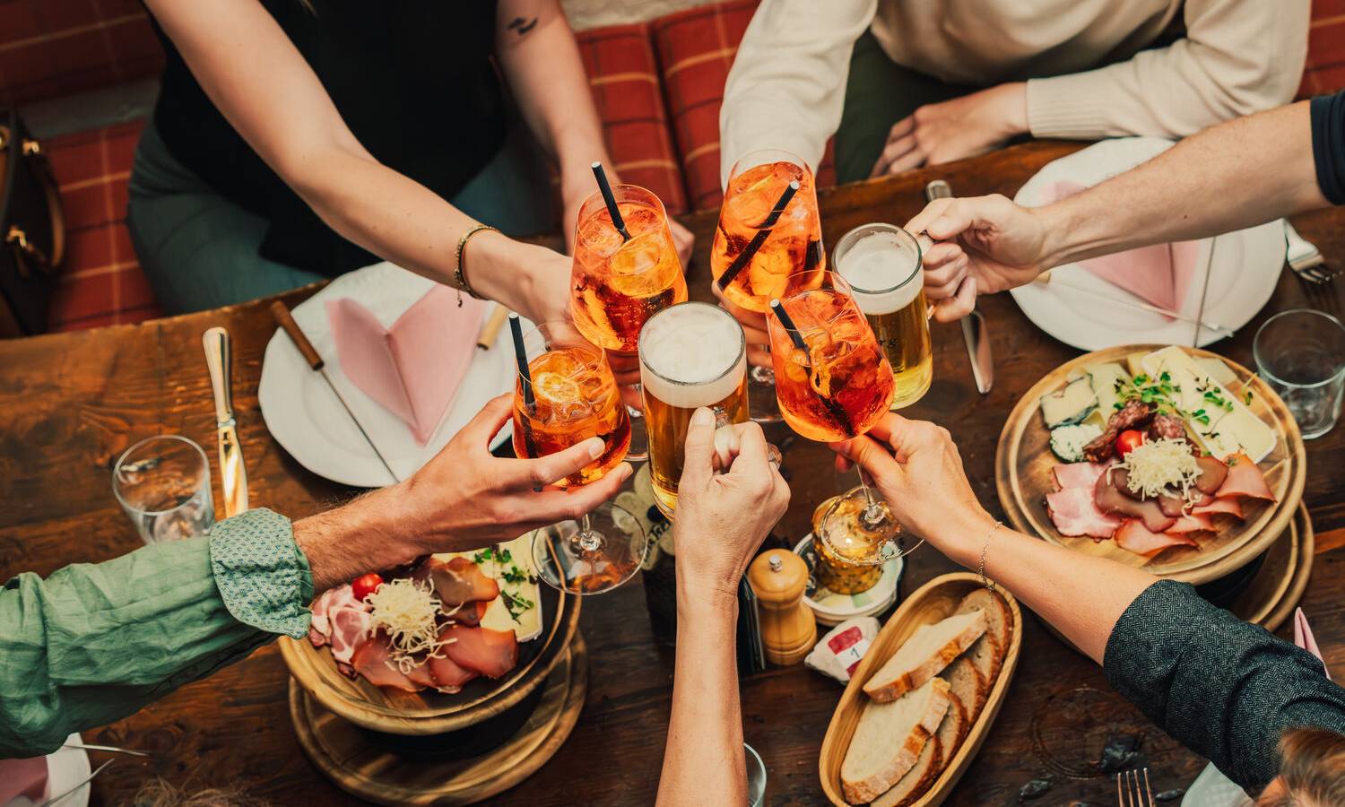 Eventtisch im Almstadl am Schwarzensee mit Tischdeko, Blumenvasen und sichtbaren Holzbalken im eleganten, rustikalen Innenraum