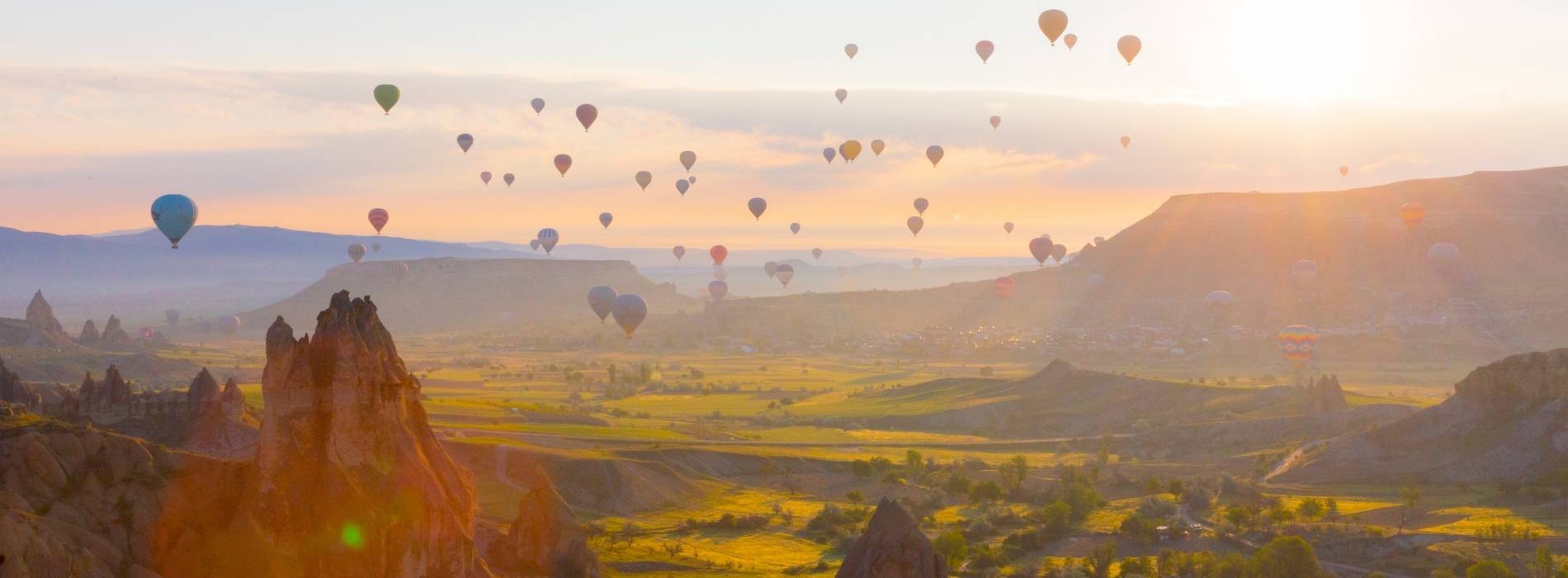 Heißluftballons über der Felsenlandschaft von Kappadokien bei Sonnenaufgang, Türkei