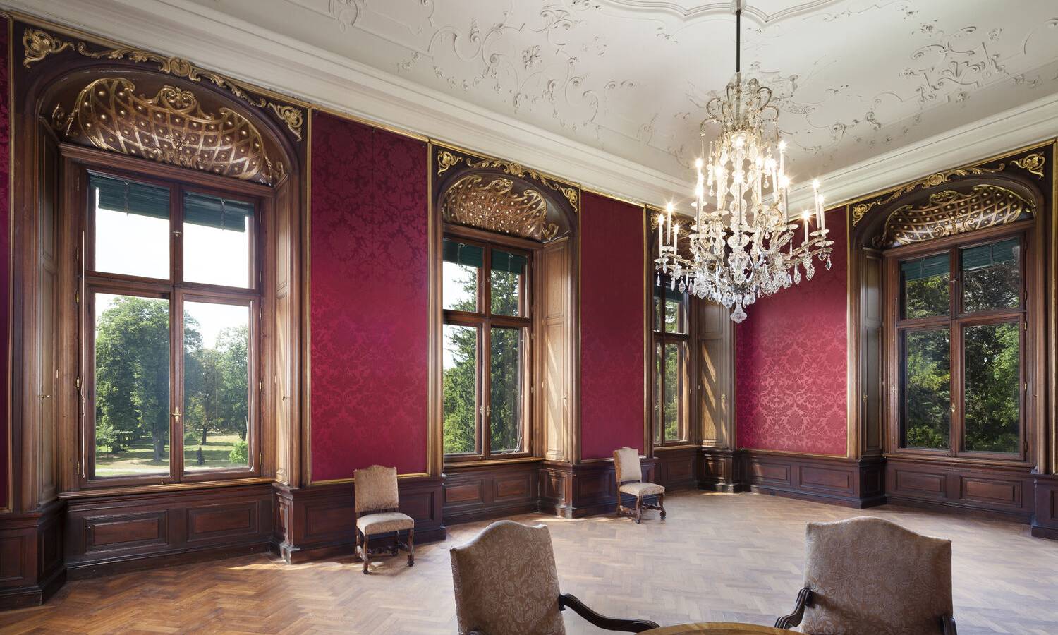 Historisches südliches Empfangszimmer im Schloss Eckartsau mit klassischem Interieur und roter Tapete