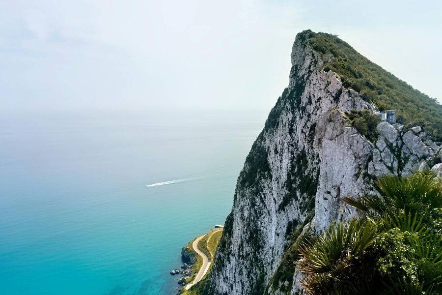 Dieses Bild zeigt den beeindruckenden Felsen von Gibraltar, der majestätisch aus dem türkisblauen Wasser aufragt. Die steilen Klippen, das üppige Grün und die spektakuläre Aussicht auf das weite Meer machen diesen Ort zu einem der ikonischsten Naturwahrzeichen Europas.