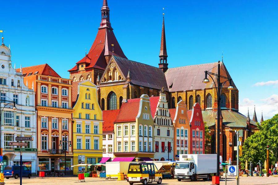 Typische, bunte Häuser umrunden einen historischen Marktplatz.