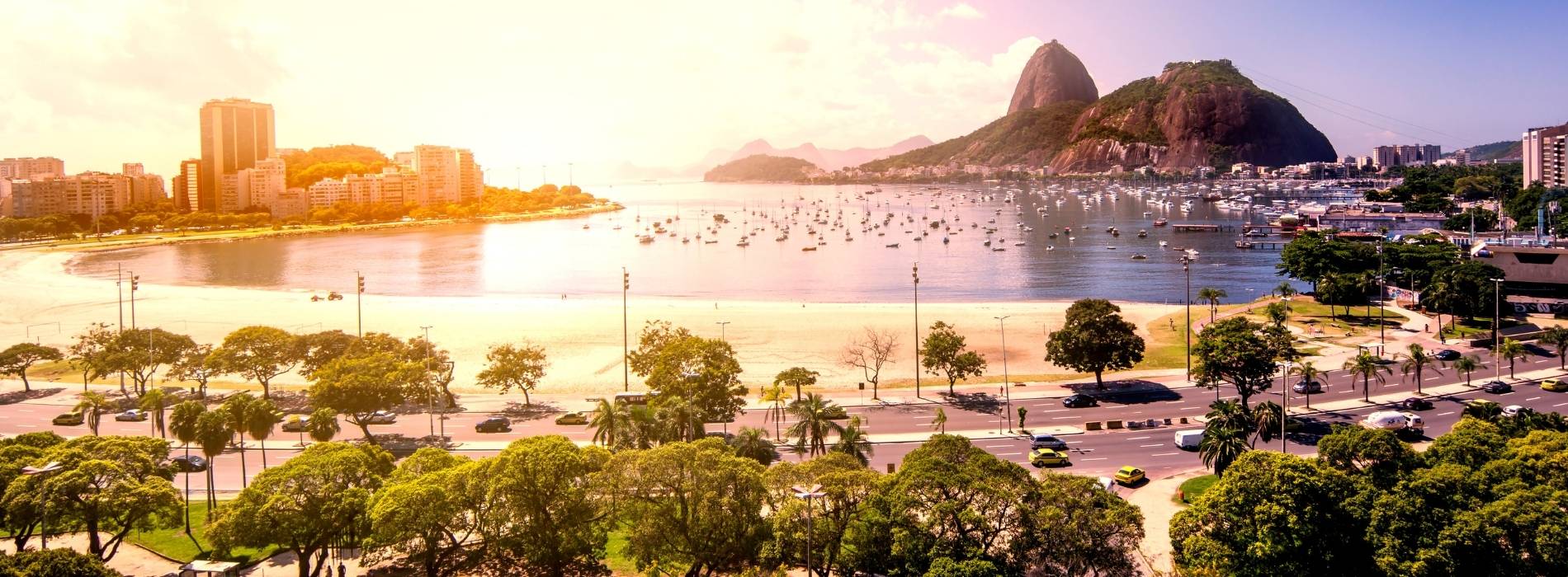 Panoramablick auf Rio de Janeiro bei Sonnenuntergang mit Zuckerhut, Küste und Stadtlandschaft.