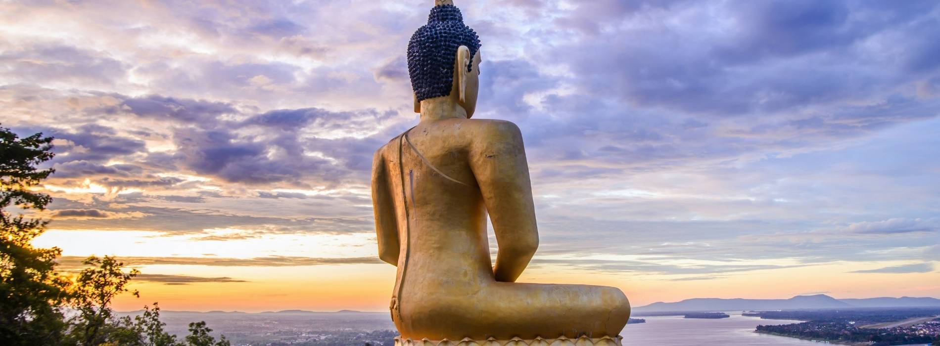 Große Buddha-Statue mit Blick über Landschaft bei Sonnenuntergang