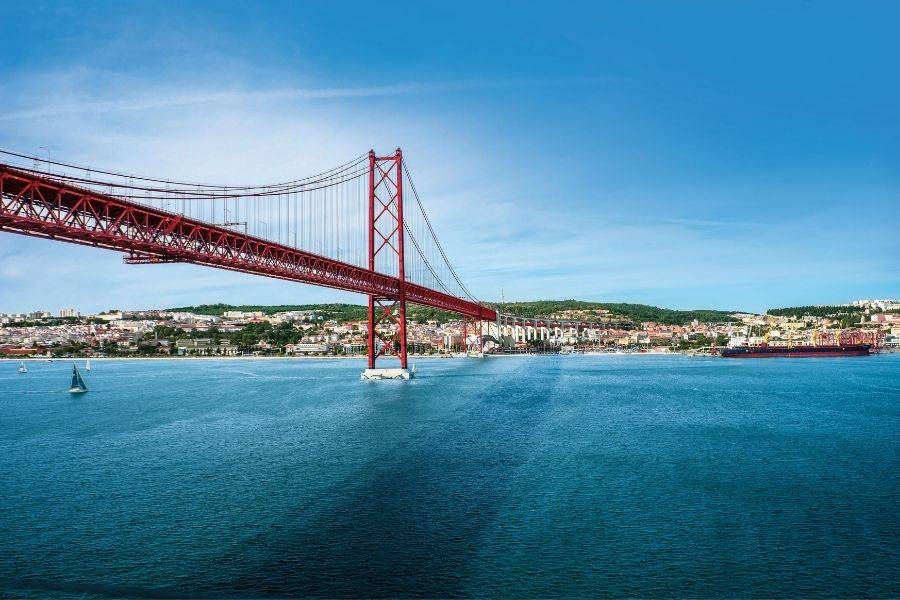 Rote Hängebrücke über dem Tejo von Lissabon mit blauem Himmel