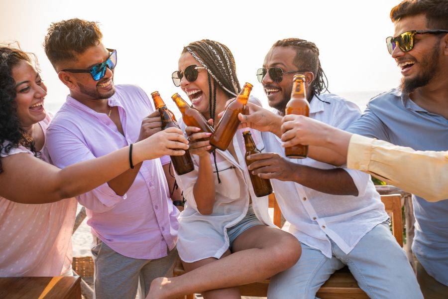 Eine Freundesgruppe hat Spaß zusammen und stößt mit Bier an.