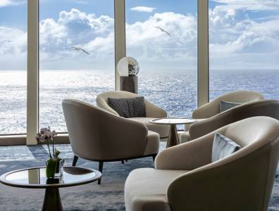 Gemütliche Sitzlounge mit Panoramafenster und Blick auf den Ozean