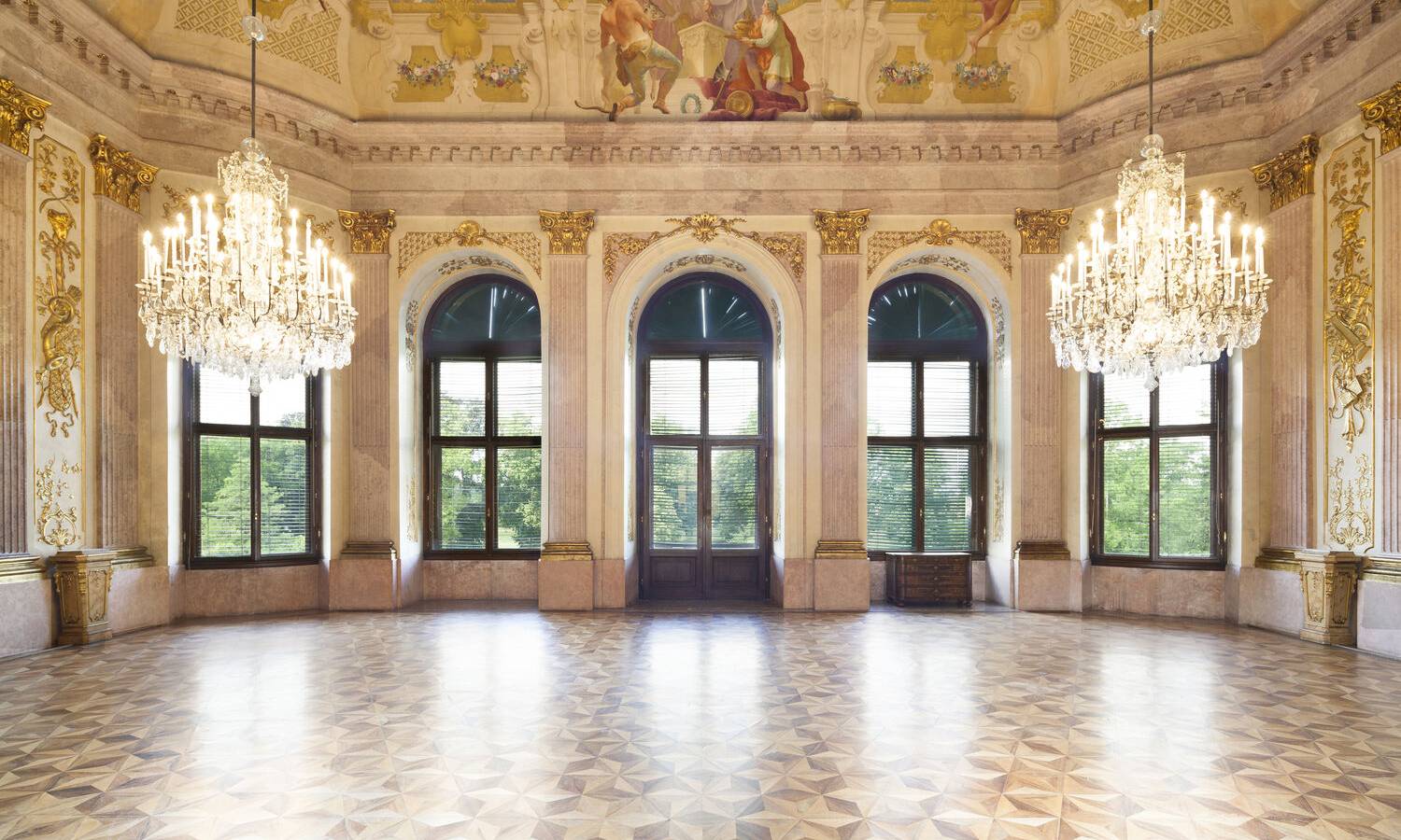 Prunkvoller Festsaal im Schloss Eckartsau mit historischem Deckenstuck und Kronleuchtern