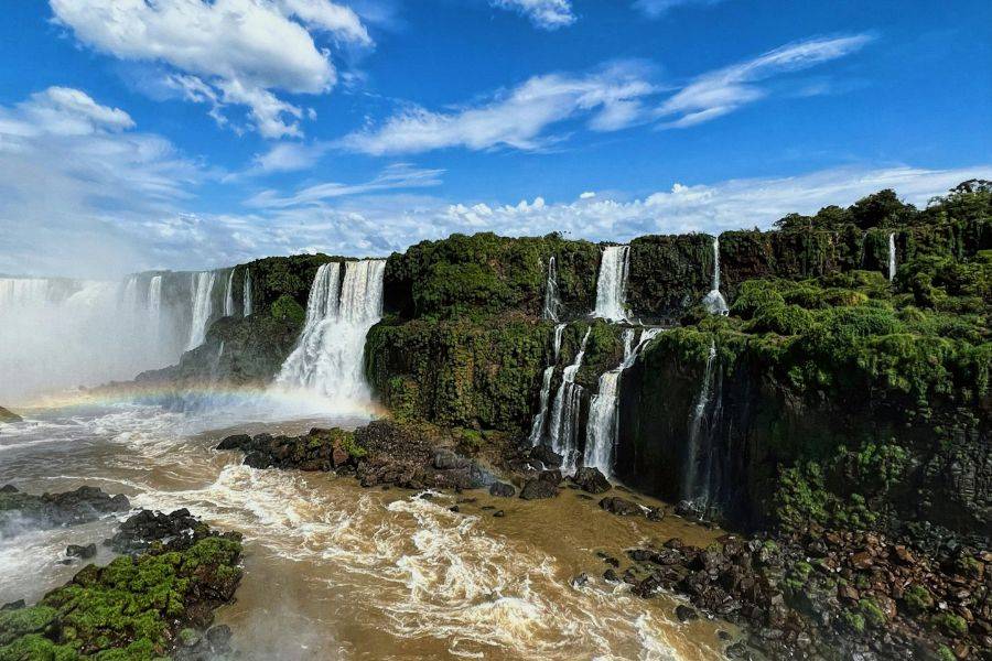 Spektakuläre Ansicht der Iguazú-Wasserfälle an der Grenze zwischen Brasilien und Argentinien – tropische Vegetation, tosende Wassermassen und Regenbogen.