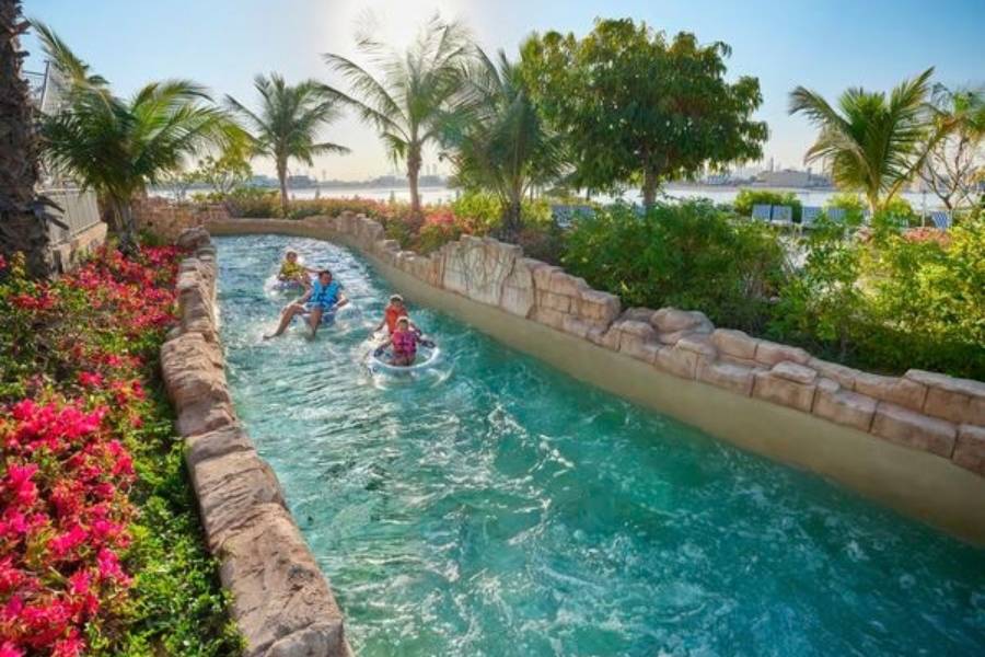 Gäste beim entspannten Reifenfahren auf einem Wasserkanal in der Aquaventure World in Dubai