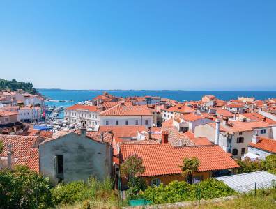 Küstenstadt Piran mit roten Dächern und Blick auf die Adriaküste in Slowenien