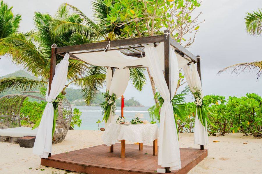 Pavillon mit Vorhängen, welcher am Strand steht