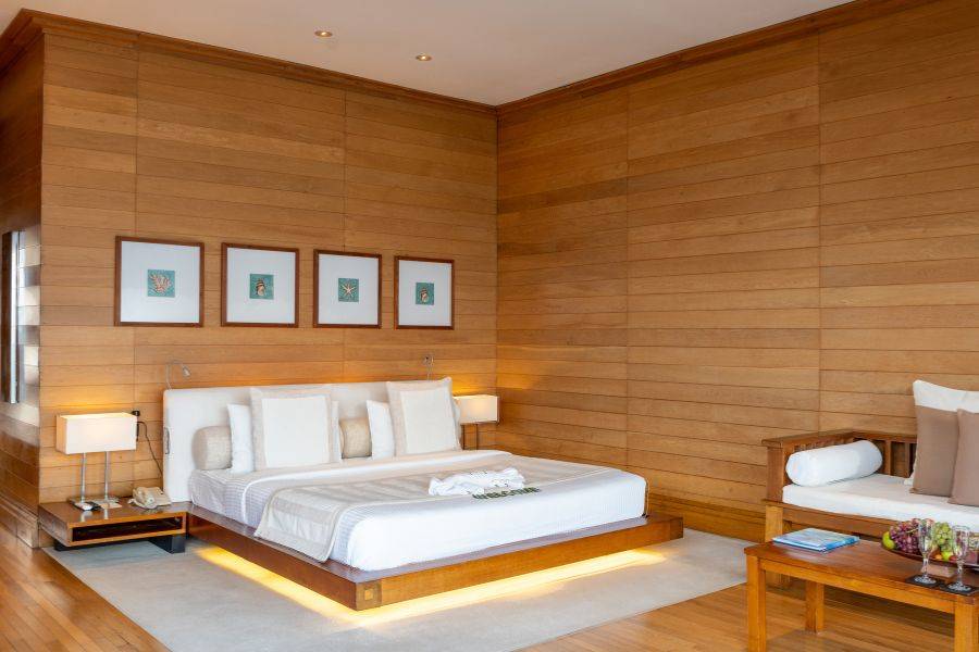 Ein Zimmer der Water Villa. Helles Holz in Kontrast mit einem weißen Bett. Sehr edle Einrichtung.