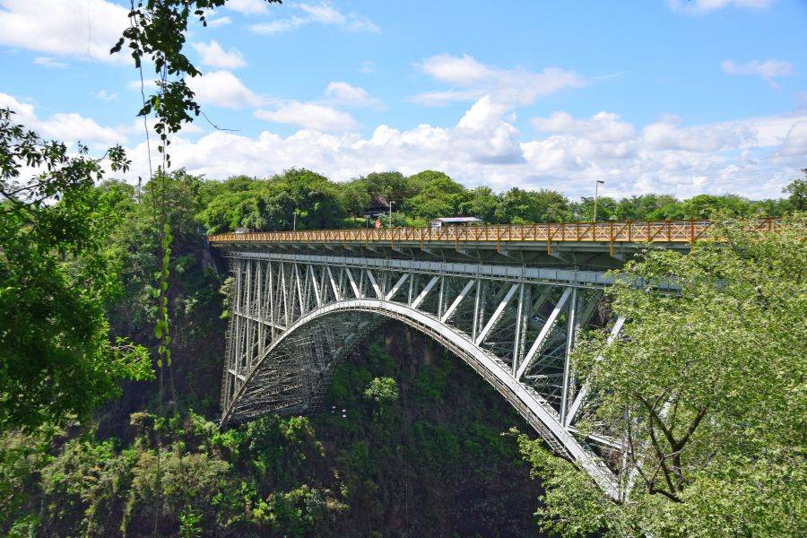 © Canva Victoria Falls Brücke umgeben von grünen Bäumen und Palmen