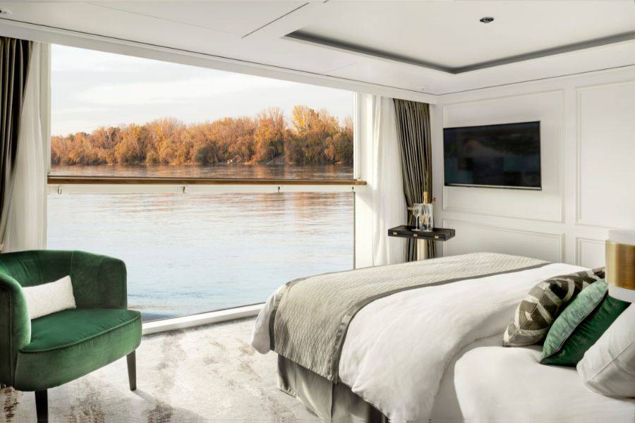 Ein stilvolles und modernes Hotelzimmer mit einem großen, einladenden Bett, dekoriert mit grünen und gemusterten Kissen. 