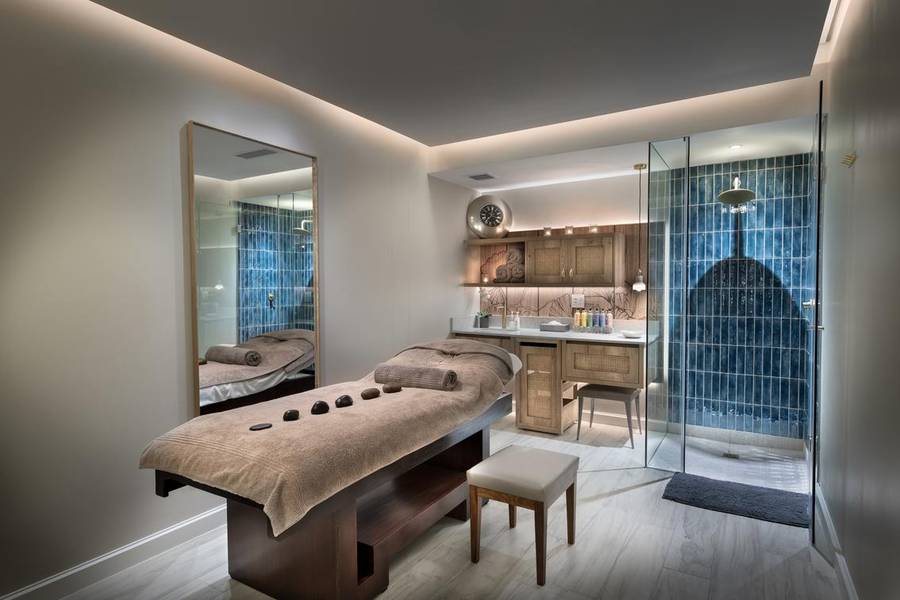 Ein ruhiger und gut beleuchteter Spa-Raum mit einer Massagetisch, beruhigendem natürlichen Licht und minimalistischen Designelementen, die eine ruhige, friedliche Atmosphäre für Entspannung schaffen