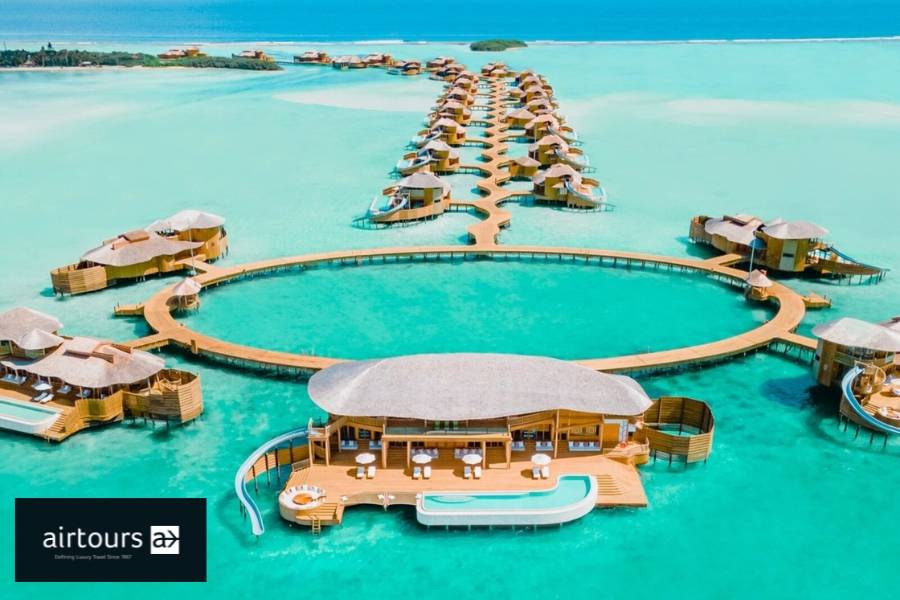 Soneva Jani aus der Vogelperspektive mit Wasservillen, privaten Pools und Rutschen entlang geschwungender Stege in der Lagune. 