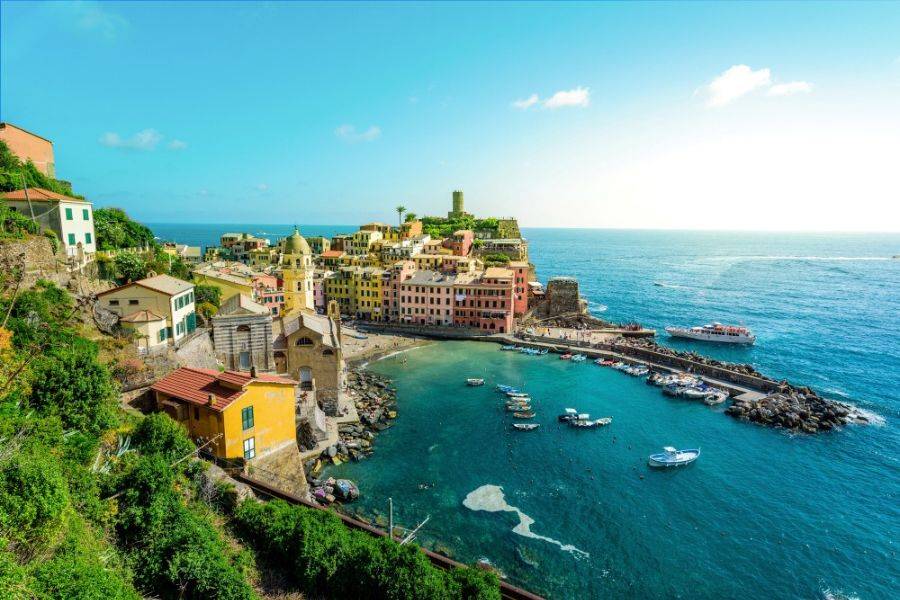 Blick auf das Küstendorf Vernazza in der Cinque Terre mit bunten Häusern, Hafen und türkisblauem Meer