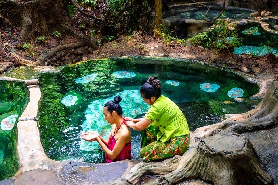 Traditionelle Healing Wellness Anwendung in Thailand mit Kräuterbad im natürlichen Thermalpool