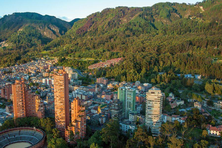 Stadtansicht von Bogotá, Kolumbien, mit Hochhäusern vor grünen Hügeln.