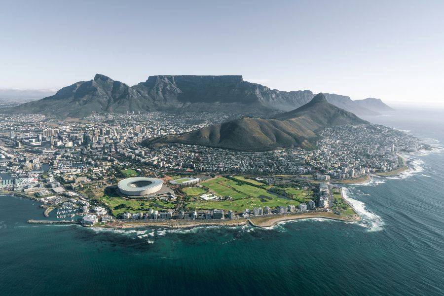 Luftaufnahme von Kapstadt mit dem Tafelberg, Signal Hill und dem Stadion an der Küste.