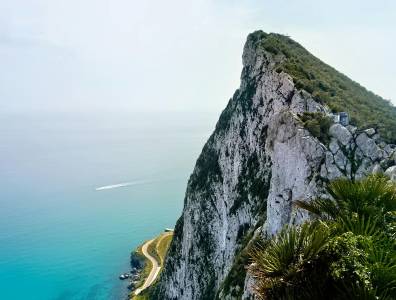 Dieses Bild zeigt den beeindruckenden Felsen von Gibraltar, der majestätisch aus dem türkisblauen Wasser aufragt. Die steilen Klippen, das üppige Grün und die spektakuläre Aussicht auf das weite Meer machen diesen Ort zu einem der ikonischsten Naturwahrzeichen Europas.