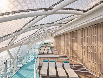 Überdachte Joggingstrecke und Liegenbereich auf einem modernen Kreuzfahrtschiff über dem Meer