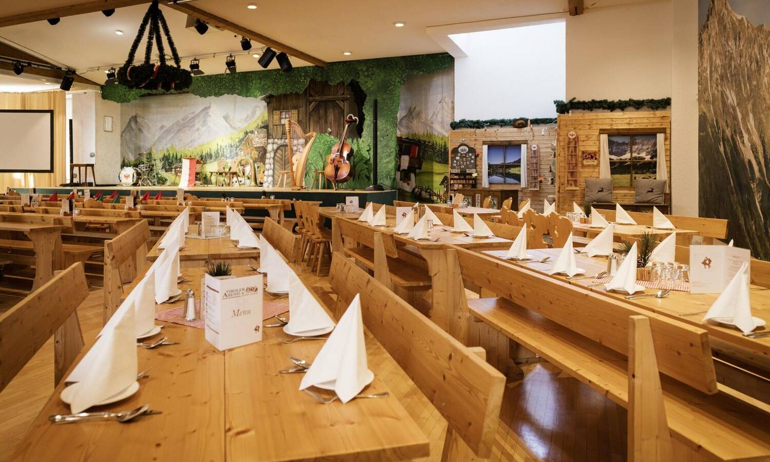 Alpensaal Innsbruck mit rustikaler Holzeinrichtung und traditionellem Tiroler Ambiente für Corporate Events Parkett Nordkette mit Bühne