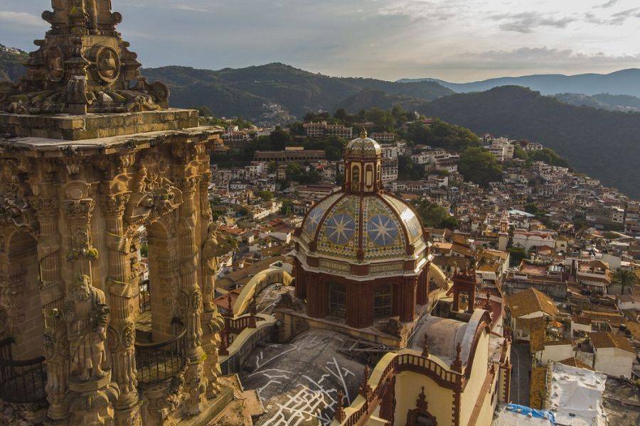 Historische Architektur einer prachtvollen Kirche in Taxco, Mexiko, mit detailreichen Säulen und einer kunstvollen Kuppel. 