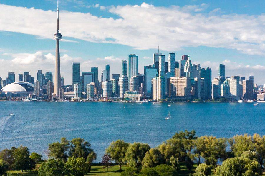 Die Skyline von Toronto. Davor sieht man den Don River und einen grünen Park.