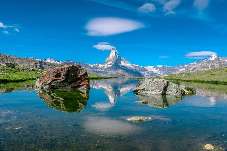 Alpiner Bergsee in den Schweizer Alpen mit Spiegelung des Matterhorns im klaren Wasser
