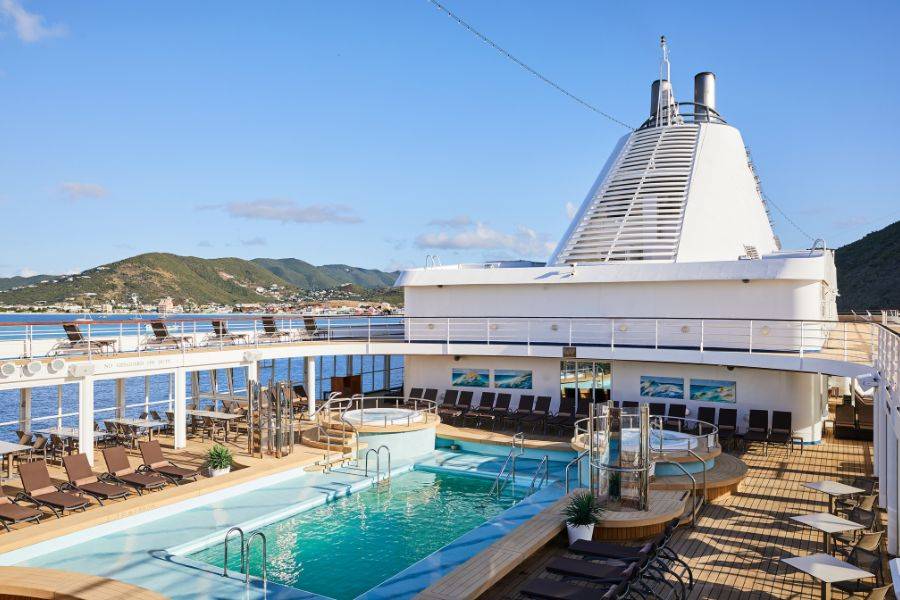 Blick auf das Deck der Silver Shadow. Man sieht den großzügigen Poolbereich, um welchen Liegen verteilt sind.