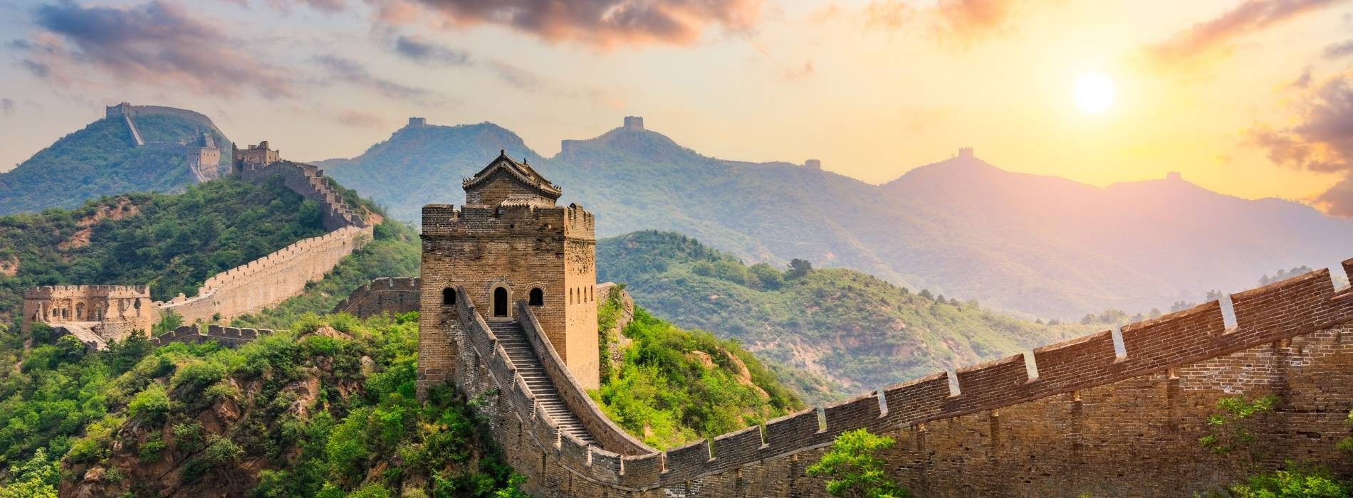 Chinesische Mauer bei Sonnenaufgang in bergiger Landschaft, China