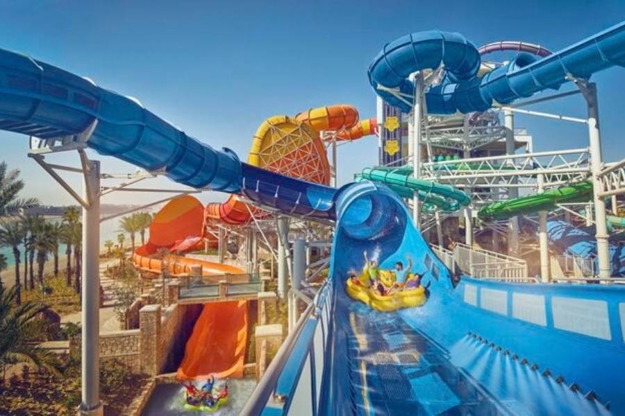 Bunte Wasserrutschen und Gäste auf Reifen in der Aquaventure World in Dubai