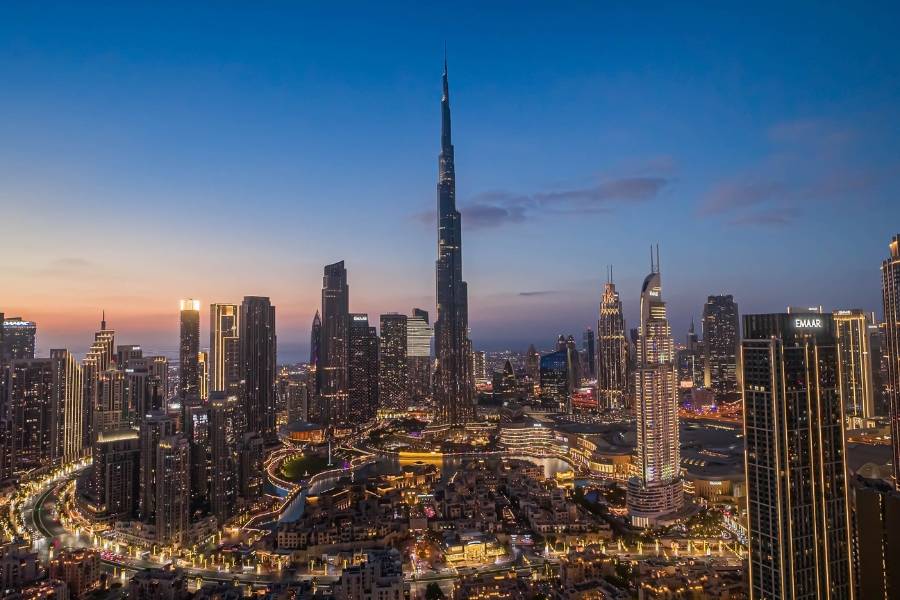 Skyline von Dubai mit dem beleuchtete Burj Khalifa bei Sonnenuntergang