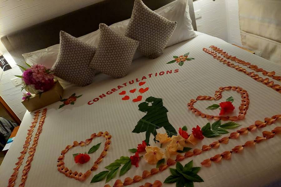 Das schön dekorierte Bett im Hotelzimmer mit Blumen und Stickereien.