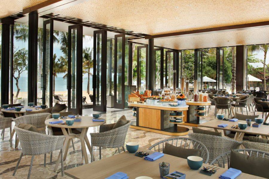 The Anvaya Beach Resort Bali – modernes Restaurant mit Blick auf den Strand und tropische Gartenanlage