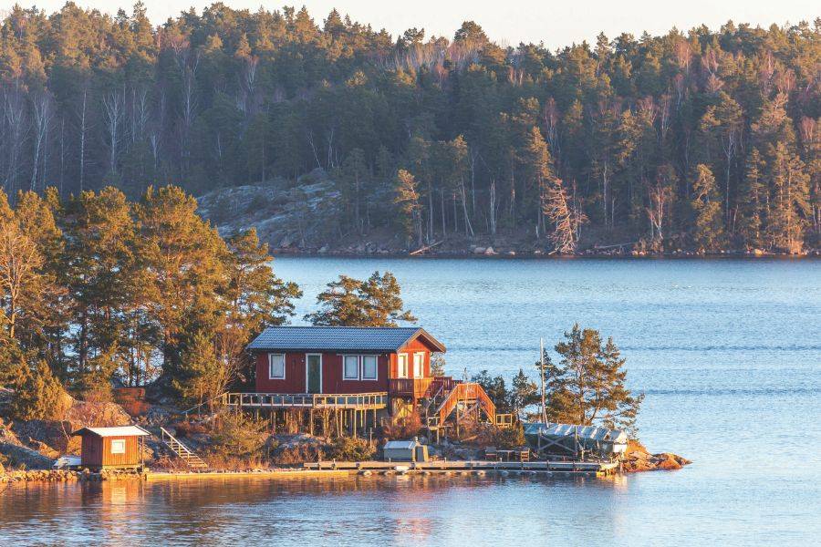 Rotes Ferienhaus am Wasser in skandinavischer Natur