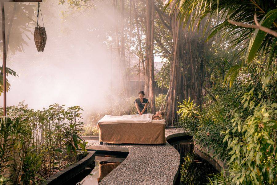 Das außergewöhnliche Spa im Grünen. Man sieht eine Frau, welche gerade eine Massage genießt.