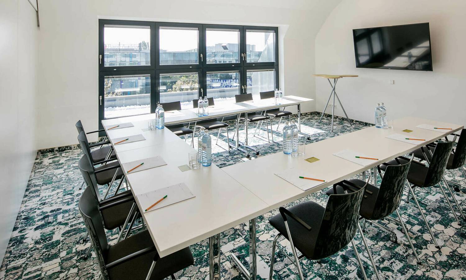 Doppelbett, Sitzecke und Tisch im modernen Hotelzimmer im ARCOTEL Donauzentrum Wien mit komfortabler Ausstattung für Geschäftsreisende und Tagungsgäste