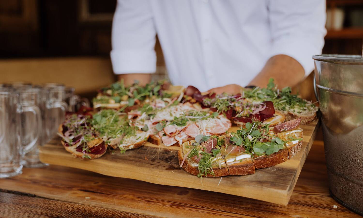Live-Auftritt im Almstadl Schwarzensee mit drei Musikern in Tracht und Zuschauern im Vordergrund