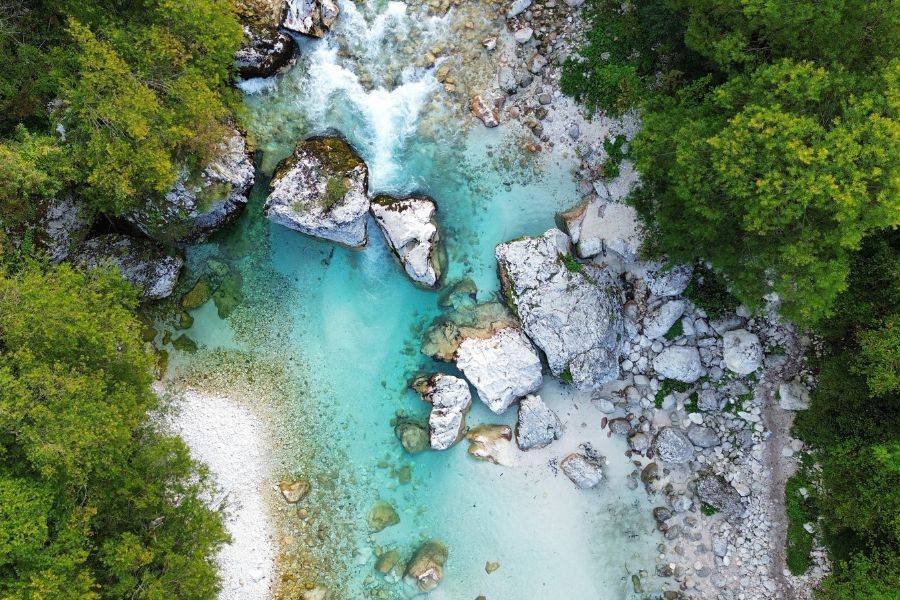 Türkisfarbener Soča-Fluss mit Felsen und dichtem Wald aus der Vogelperspektive in Slowenien