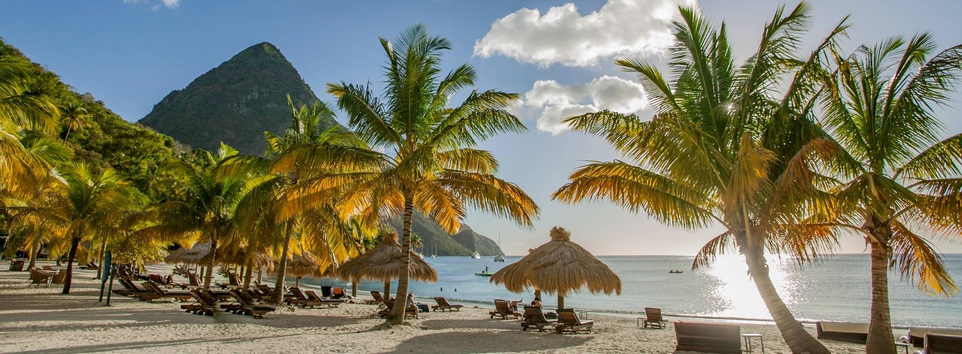 Tropischer Strand mit Palmen, Liegen und Blick auf die Pitons auf Saint Lucia.