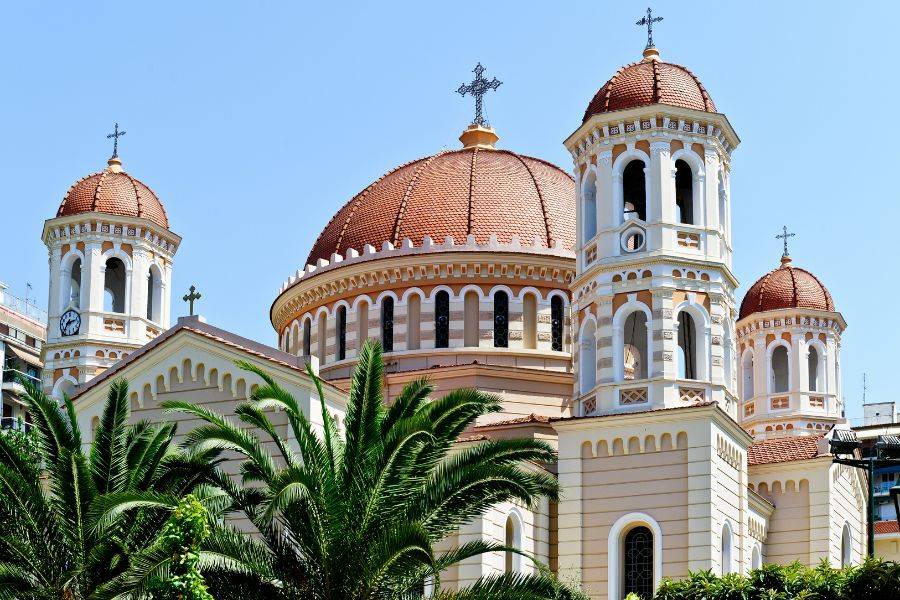 Byzantinische Kirche mit roten Kuppeln und Palmen in Thessaloniki