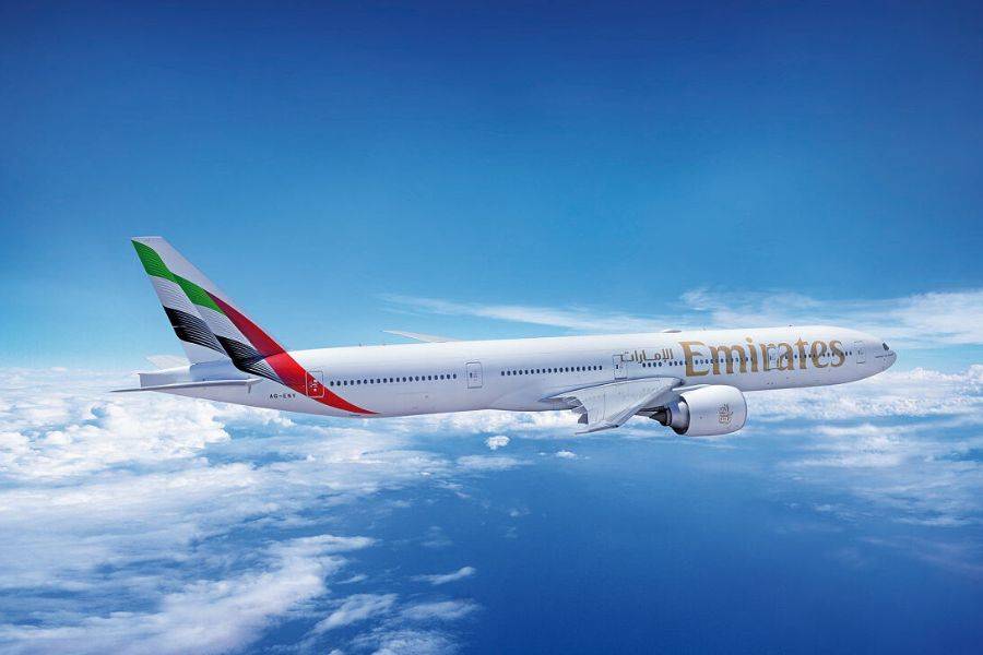 © Emirates Emirates Boeing 777-300ER über den Wolken bei blauem Himmel