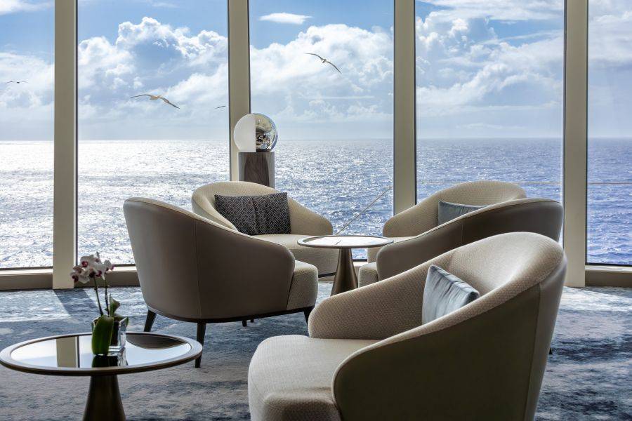 Gemütliche Sitzlounge mit Panoramafenster und Blick auf den Ozean